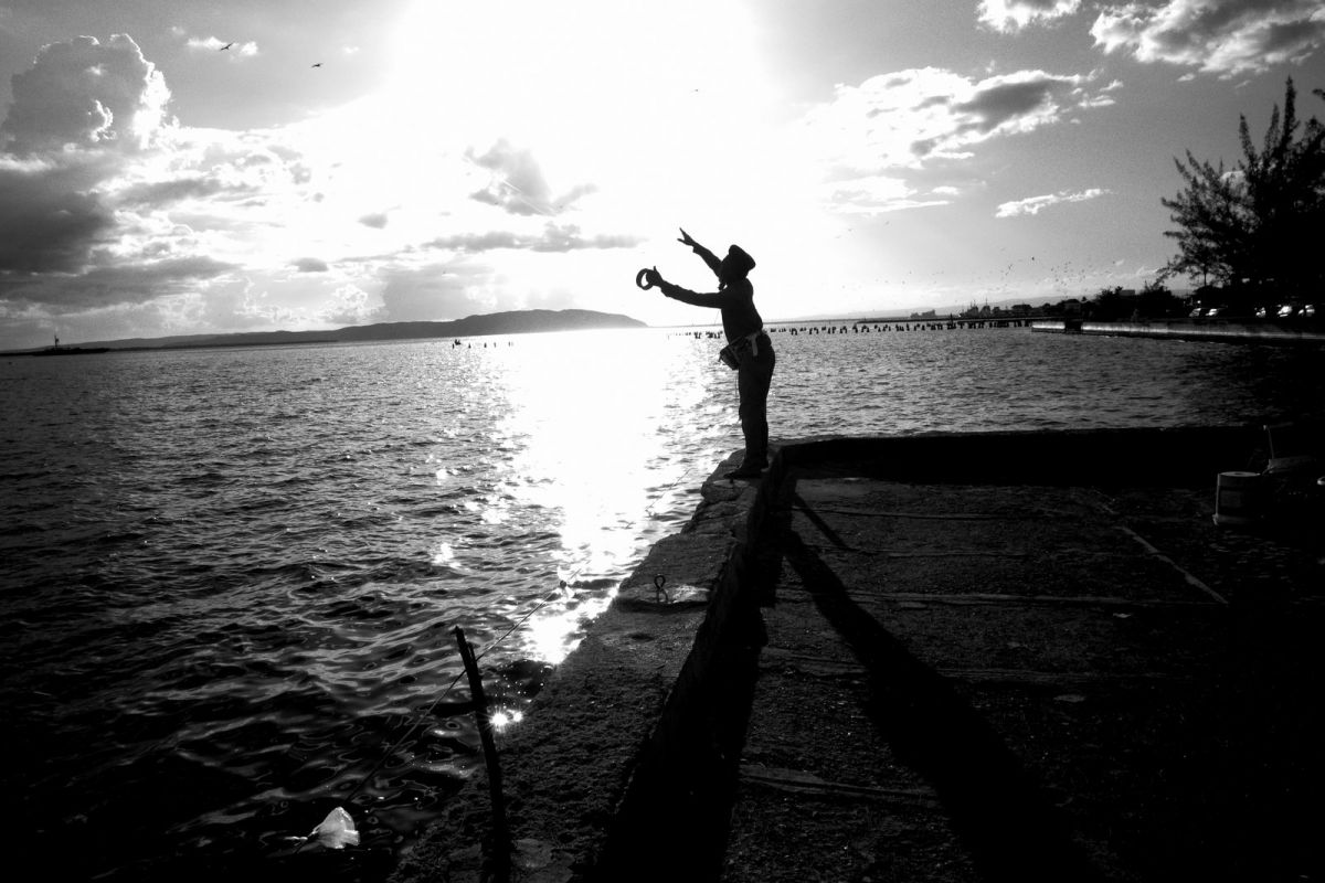 fishman casting a line Downtown  Kingston waterfront.